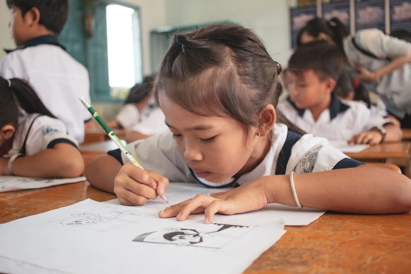 A student drawing at her desk